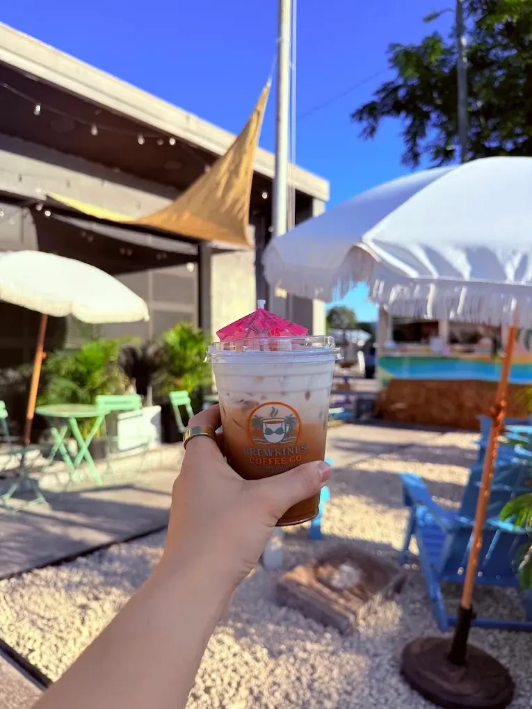 An iced latte held up on the BrewKini’s patio